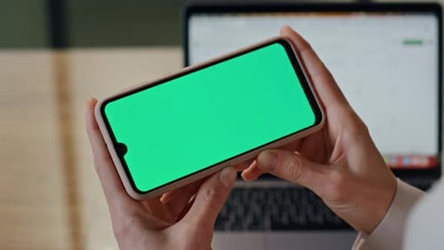 Woman Holds Phone with Green Screen in Office