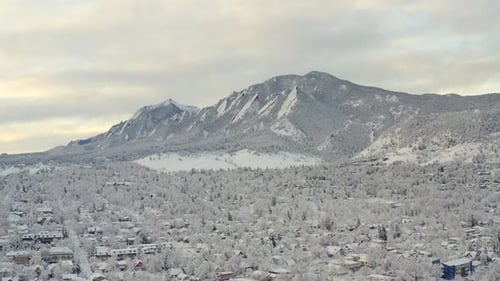 High wide drone shot moving forward of Boulder Colorado and rocky Flatiron mountains after large win