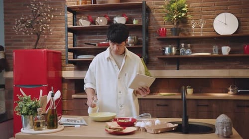 Man Following Recipe on Tablet in Kitchen