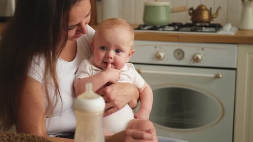 Woman Holding Adorable Baby Indoors