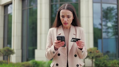 Worried Woman Outside With Credit Card and Phone
