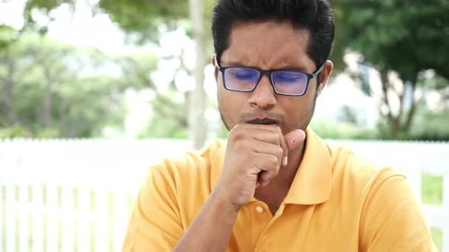 Mature Man Coughing Sitting on Sofa