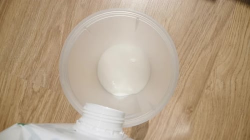 White Liquid being Poured into a Clear Container