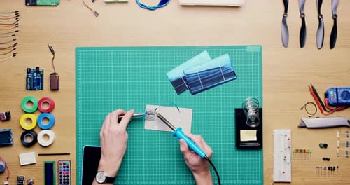 Top view of electrician soldering a circuit board for engineering, hardware construction