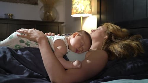 Baby Sleeping on Top of Woman Lying on Bed