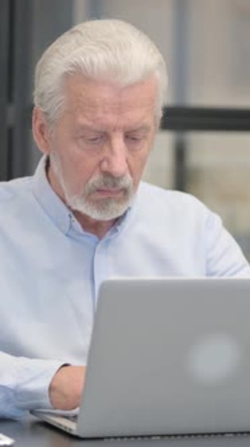 Old Businessman Working on Laptop in Office, vertical video