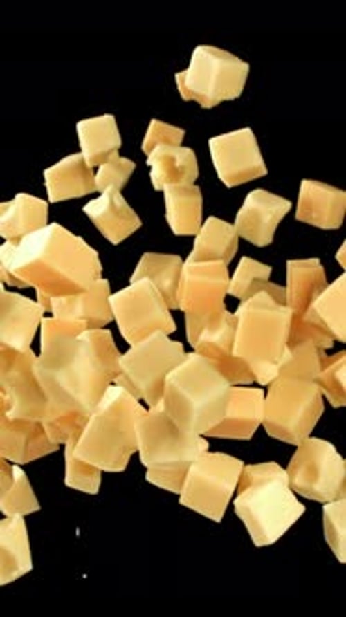 Maasdam Cheese Flies Up and Falls Down on a Black Background Filmed on a Highspeed Camera at 1000