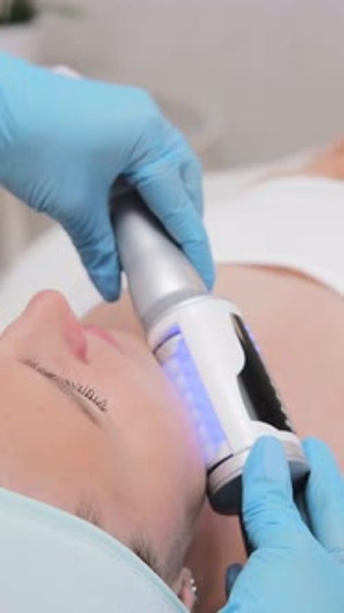 Woman Getting Medical Facial Treatment with Device