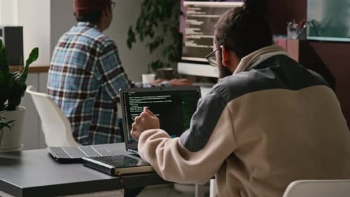 Two Busy Male Programmers Working on Code in Office