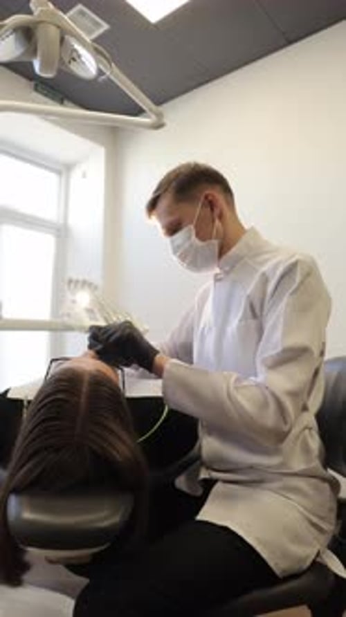 Dental Practitioner in Clean Clinic Meticulously Handling Patient with Small Tools During Routine