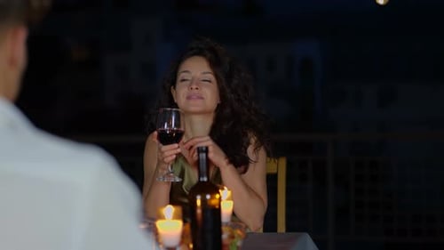 Smiling Pretty Lady Holding Glass of Wine While Sitting at the Table on Terrace and Having Date