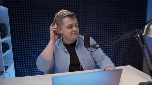Handsome Radio Host Sit in Studio and Communicates with Audience Man in Blue Shirt and Headphones