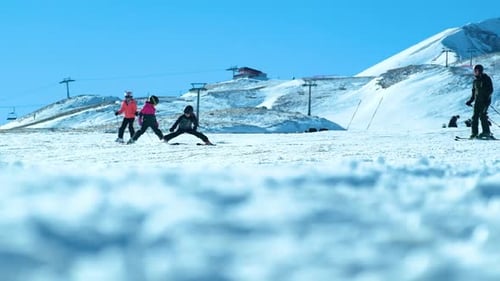 People Skiing Down Snow Covered Mountain on Sunny Day
