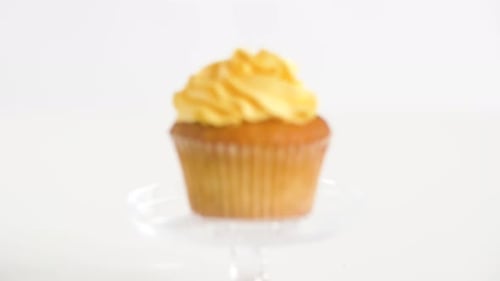 Delicious cupcake with yellow frosting on display stand
