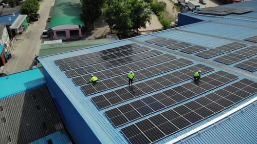 Aerial top view of engineer worker installing solar photovoltaic panels on roof