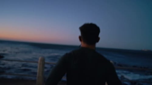 Runner man, night and beach with music, earphones and thinking at workout, training and outdoor