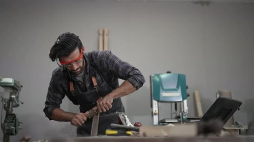 Carpenter is working at workshop.