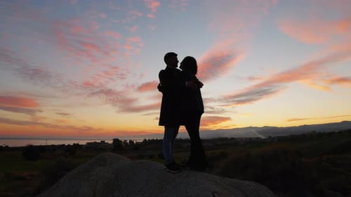 Silhouetted Couple Embracing at Colorful Sunrise