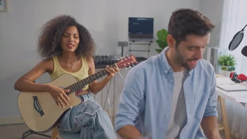 Young Adults Singing and Playing Acoustic Guitar