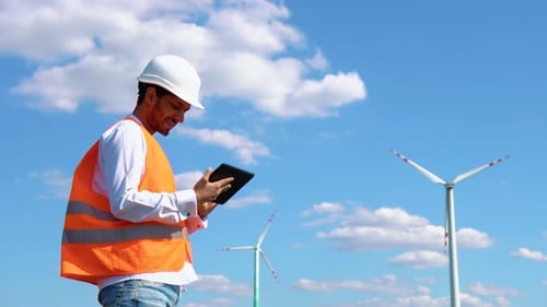 Indian Engineer Working with Tablet at Windmill Farm Generating Electricity Clean Energy Asian