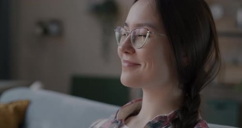 Woman Drinks from Mug Indoors and Smiles