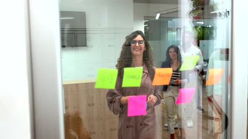 Diverse Team Brainstorming Ideas on Glass Wall