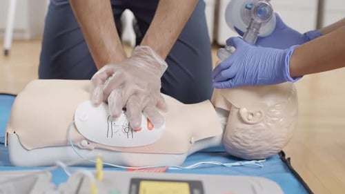 First aid training session at the clinic with medical professionals practicing on a mannequin