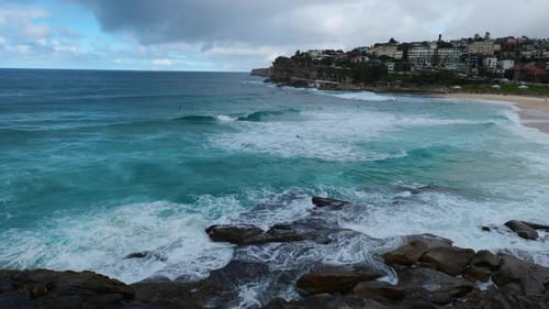 Powerful ocean waves crash against the shoreline of Bronte Beach, creating a mesmerizing display of