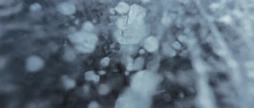 Close up of white bubbles and ice cracks in the frozen lake