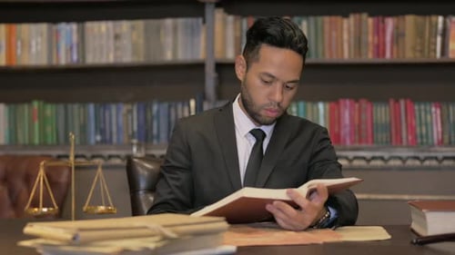 Lawyer Reading Law Book at His Desk