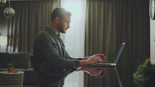 Young Adult Typing on Laptop at Home Indoors