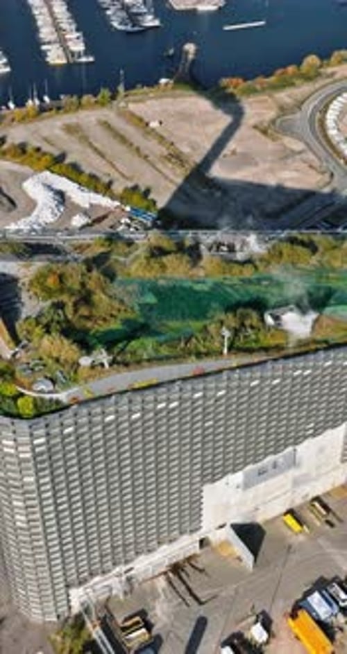 Aerial drone view of CopenHill artificial ski slope on the roof of an energy plant. Vertical