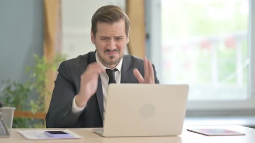 Frustrated Man Working at Computer in Office