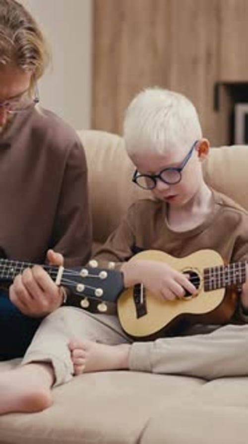 Child Learns Ukulele with Adult Guidance at Home
