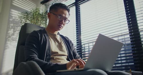 Camera Bottom View of Handsome Asian Man Working in Cosy Office with Panoramic Windows Busy Worker