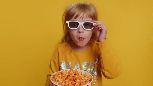 Child Eats Popcorn Wearing 3D Glasses