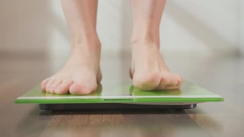 Frauenfüße treten auf Bodenwaagen