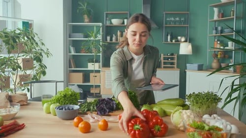 Woman Browsing Tablet with Fresh Food on Counter