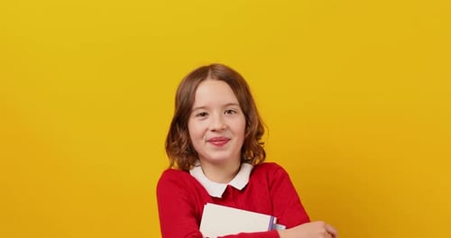 Smiling Child With Book on Yellow Background