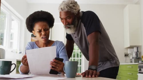 Concerned african american couple sitting paying bills