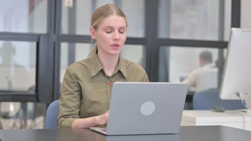 Woman Coughing While Working on Laptop in Office