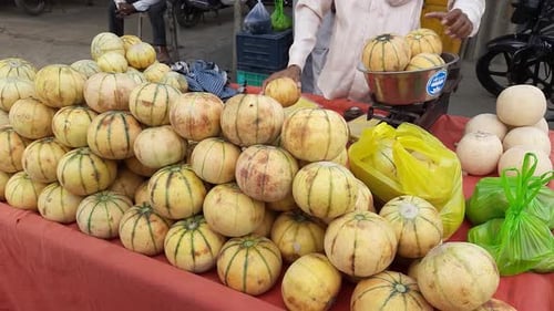 Un homme vend du melon musqué dans une brouette Thela Gaadi sur Roadside of India