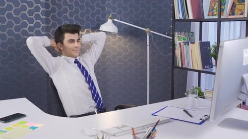 Young Adult Relaxing at Desk in Modern Office