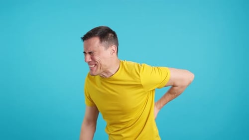 Man Gesticulates That He is in Back Pain