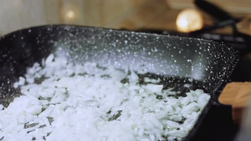Diced Onions Sizzle in Frying Pan Close Up