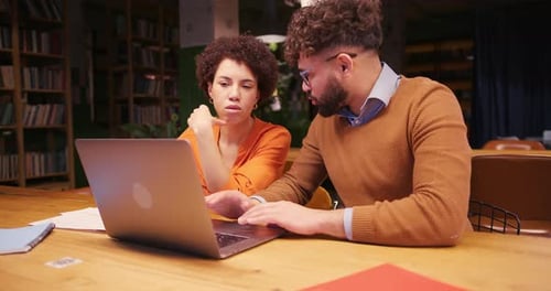 Professional Colleagues Analyzing Documents Using Laptop Working in Modern Office
