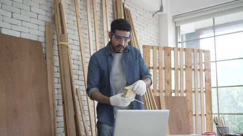 Carpenter is working at woodshop.