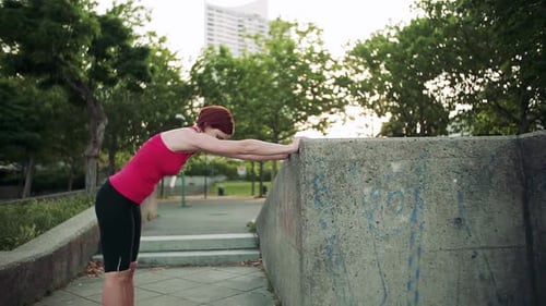 Young Woman Doing Exercise Outdoors in City, Stretching