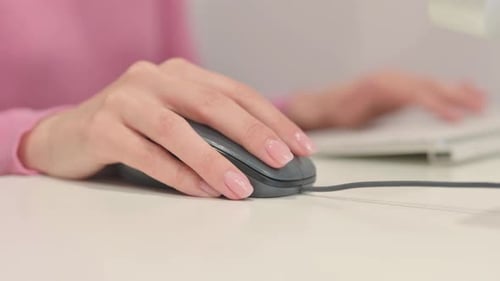 Woman's Hand Using Computer Mouse in Office