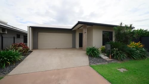 Medium Sized Garage Driveway Frontage With Tropical Plants and Concrete Pillars. Exterior of house h